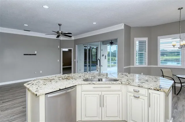 a kitchen with stainless steel appliances granite countertop a sink stove and white cabinets with wooden floor