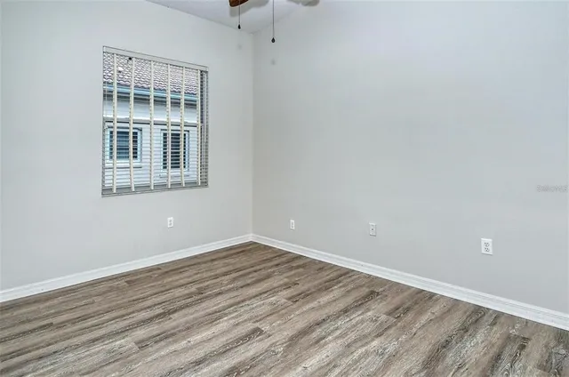 a view of an empty room with wooden floor and closet