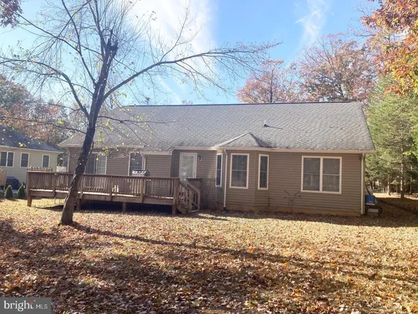 a front view of a house with a yard covered in snow