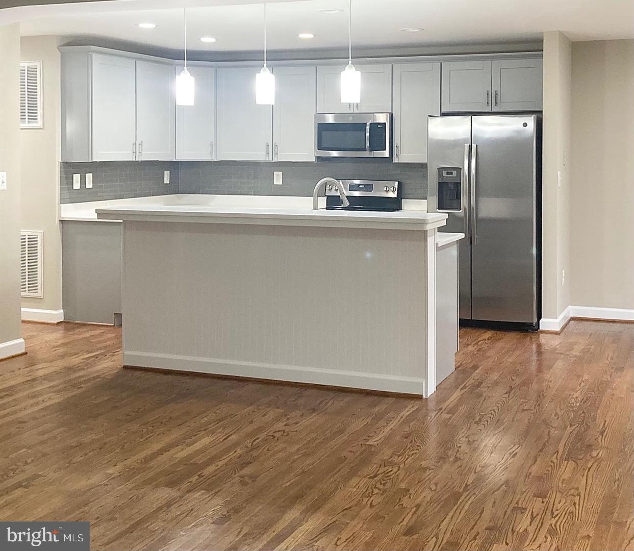 3002 Lakeview Parkway Locust Grove, VA 22508 - Photo 3 of 18 a kitchen with stainless steel appliances granite countertop a refrigerator a sink a stove a microwave and white cabinets with wooden floor