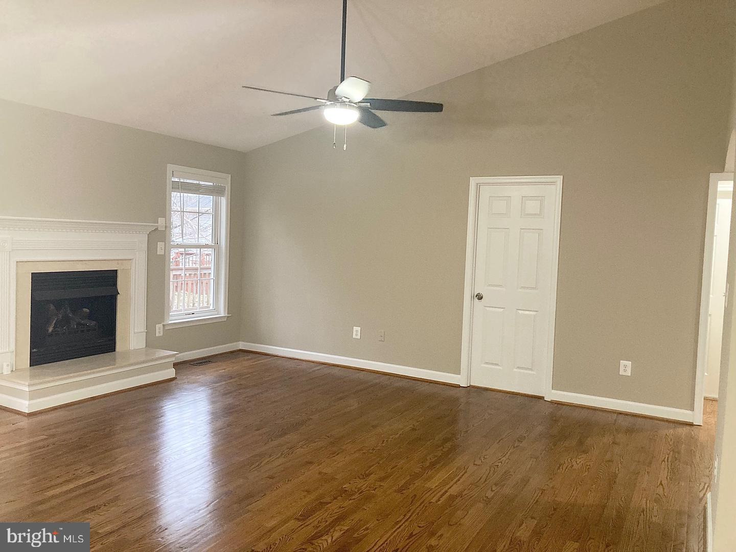 3002 Lakeview Parkway Locust Grove, VA 22508 - Photo 9 of 18 an empty room with wooden floor fireplace and windows
