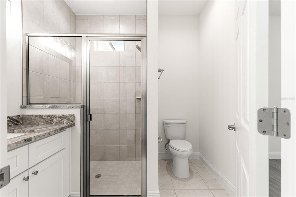 12411 Southwest 71st Lane Road Ocala, FL 34481 - Photo 38 of 50 a bathroom with a granite countertop sink a toilet and shower