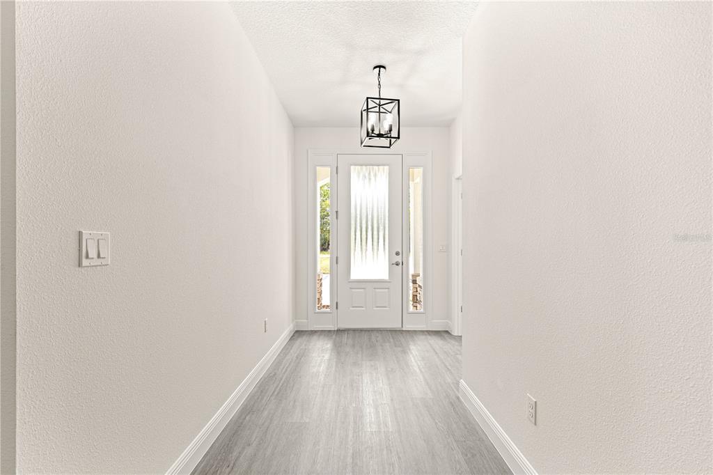 12411 Southwest 71st Lane Road Ocala, FL 34481 - Photo 7 of 50 a view of a hallway with wooden floor