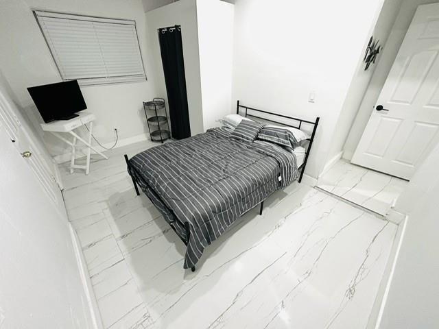 55 Northwest 47th Street Miami, FL 33127 - Photo 11 of 31 a bedroom with a bed tv and a mirror