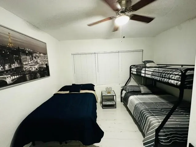 a bedroom with double bunk beds and a ceiling fan