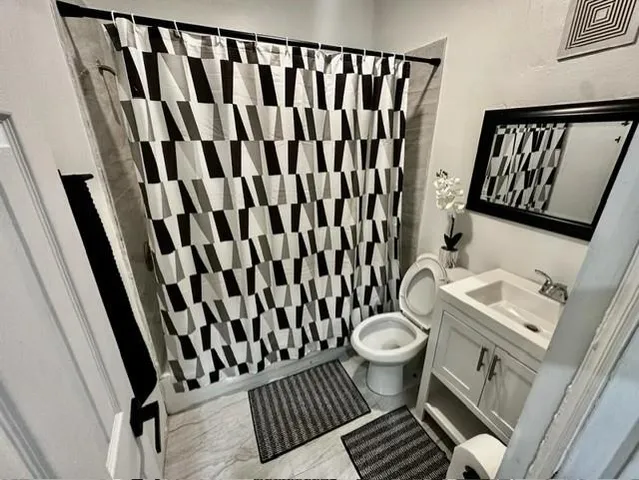 a bathroom with a toilet and a mirror