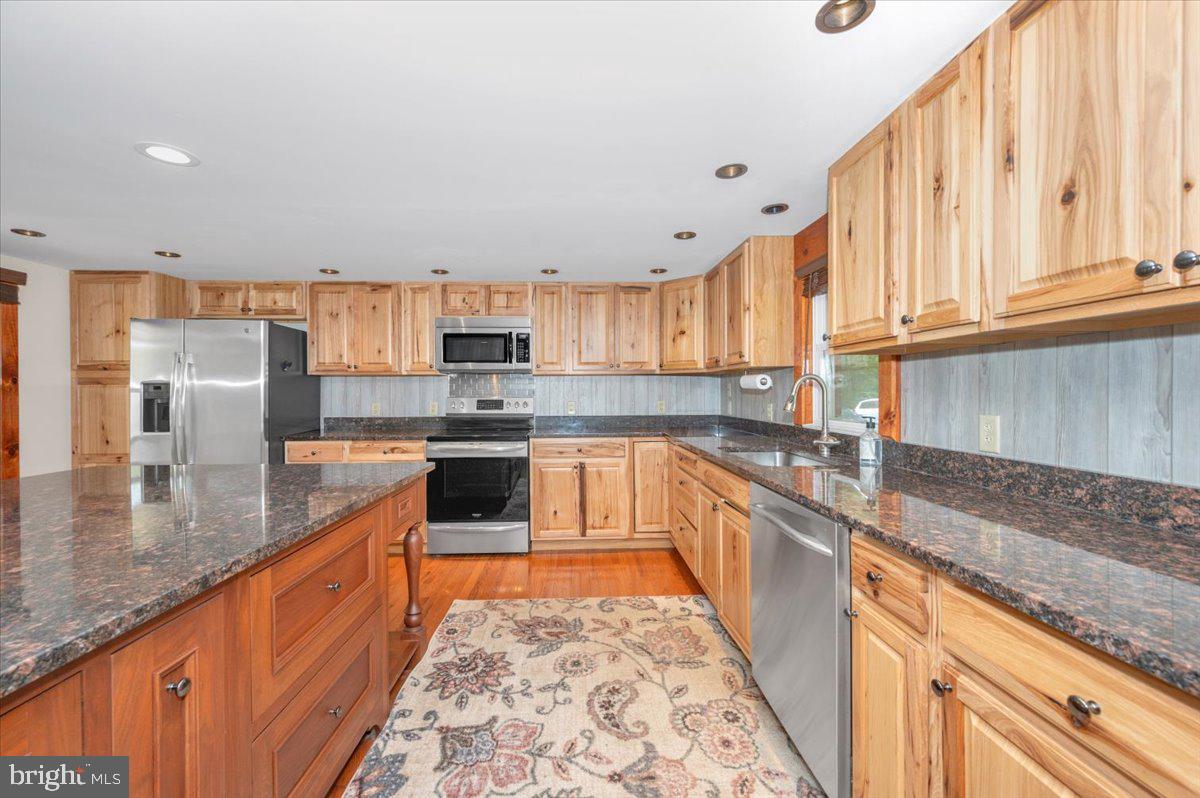 7010 Old Pryor Road Thurmont, MD 21788 - Photo 16 of 62 a large kitchen with stainless steel appliances granite countertop a stove a sink and a granite counter tops