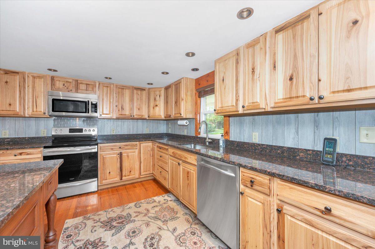 7010 Old Pryor Road Thurmont, MD 21788 - Photo 17 of 62 a kitchen with stainless steel appliances granite countertop a sink a stove and cabinets