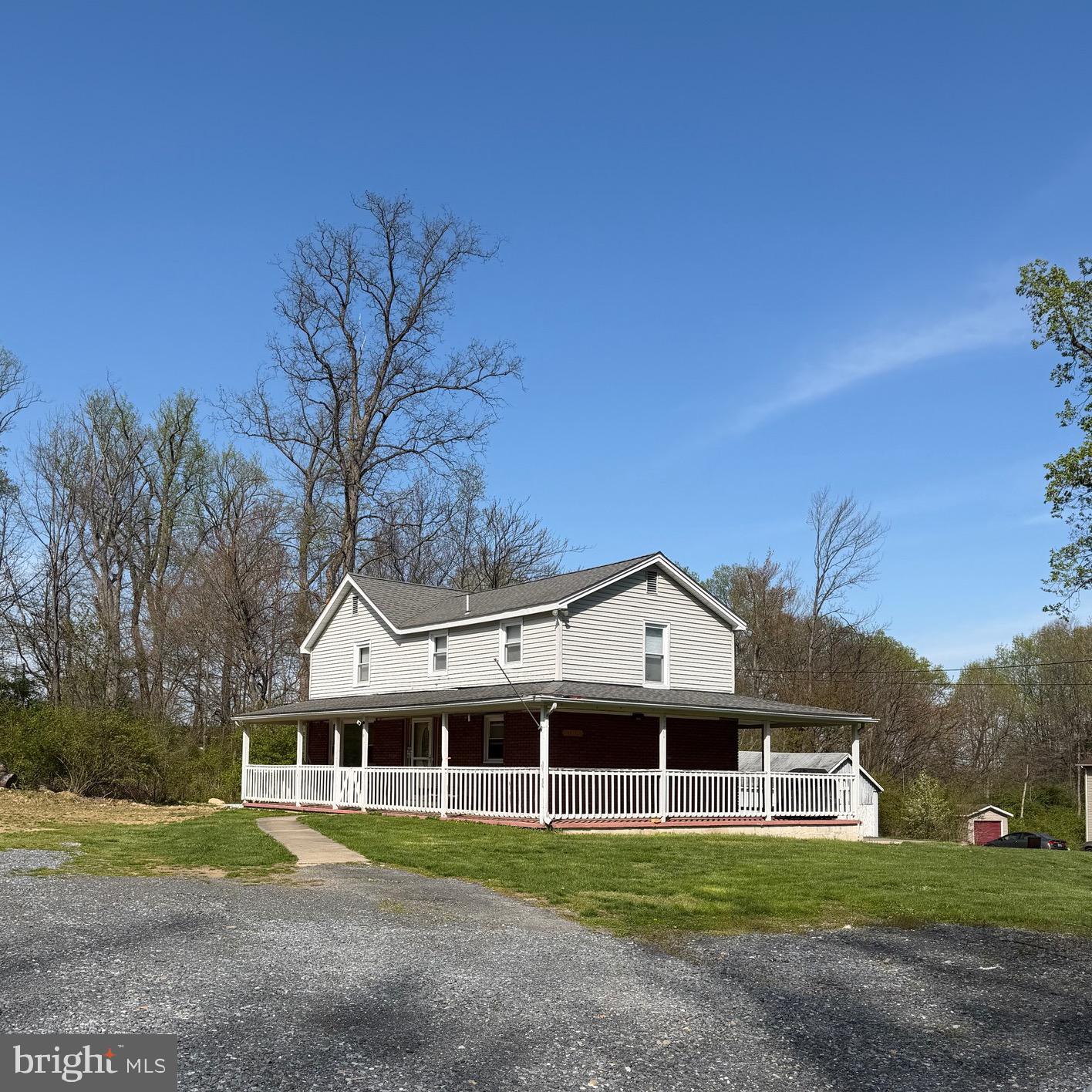 7010 Old Pryor Road Thurmont, MD 21788 - Photo 2 of 62 a view of a white house next to a yard with big trees and plants