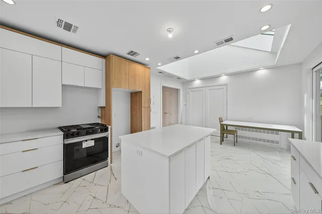 a kitchen with a stove a refrigerator and white cabinets