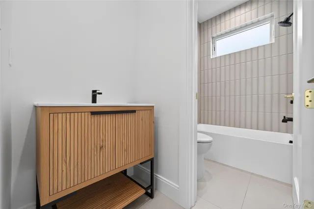 a bathroom with a white bathtub and toilet