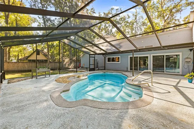 a view of a house with backyard area and swimming pool