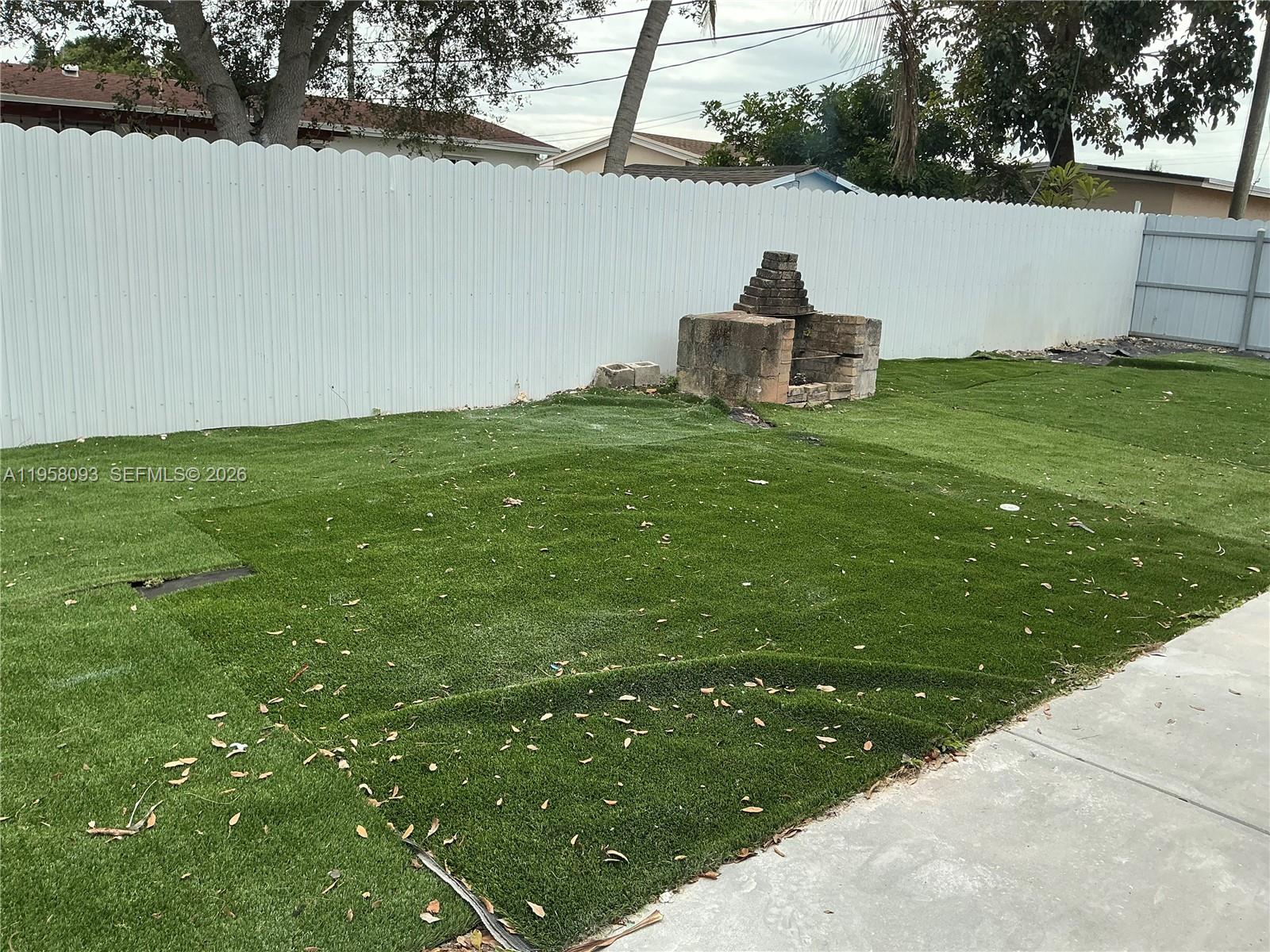 14821 Southwest 104th Avenue Miami, FL 33176 - Photo 3 of 4 a backyard of a house with table and chairs