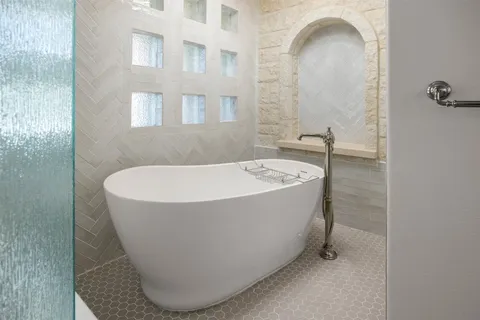 a bathroom with a tub sink and mirror