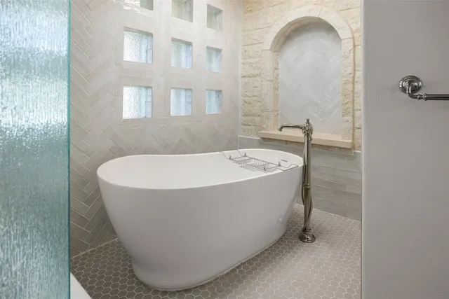 a bathroom with a tub sink and mirror