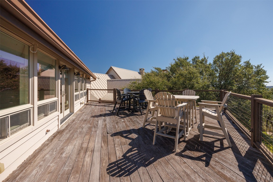 470 Inspiration Trail Wimberley, TX 78676 - Photo 27 of 30 a view of a roof deck with table and chairs a barbeque with wooden floor and fence