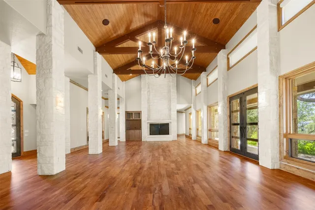 a view of a big room with wooden floor and chandelier