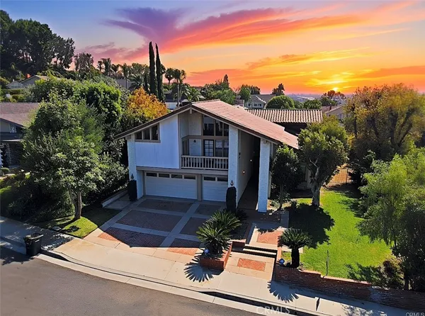 an aerial view of a house with a yard and potted plants