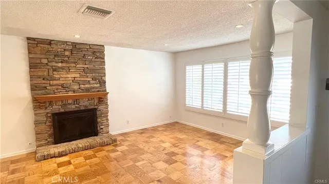 a view of an empty room with a fireplace and a window