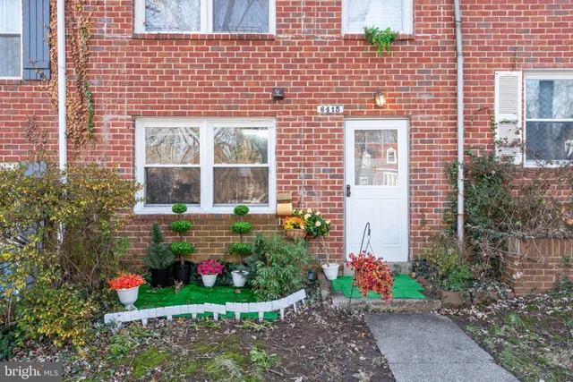 a front view of a house with a yard and potted plants