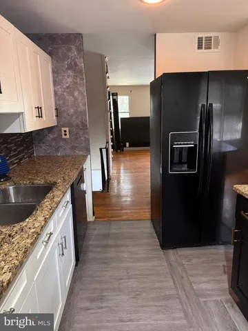 a kitchen with stainless steel appliances granite countertop a refrigerator a stove and a sink