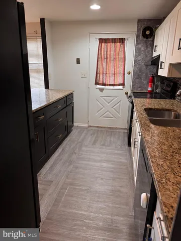 a kitchen with granite countertop a stove a sink and a microwave