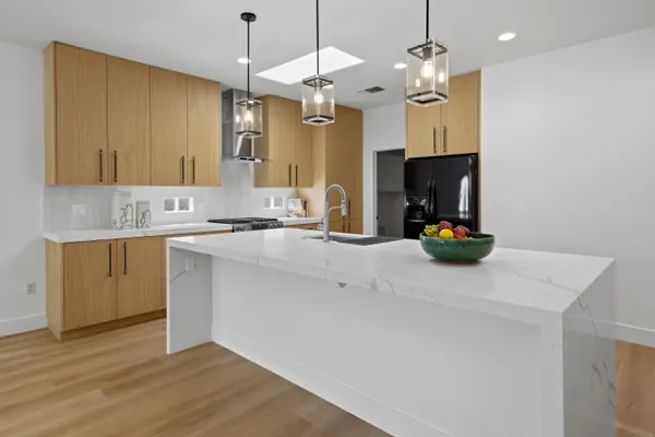 a kitchen with a sink a microwave a stove and cabinets