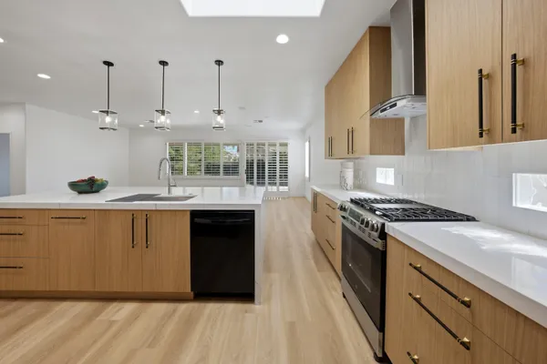 a kitchen with stainless steel appliances granite countertop a stove a sink and a refrigerator