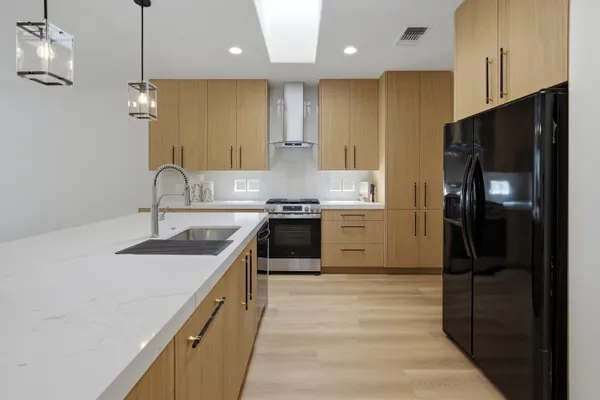 a kitchen with stainless steel appliances granite countertop a sink a stove and a refrigerator