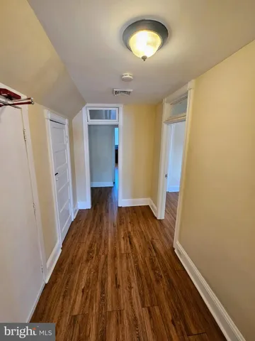 a view of a room with wooden floor and entryway