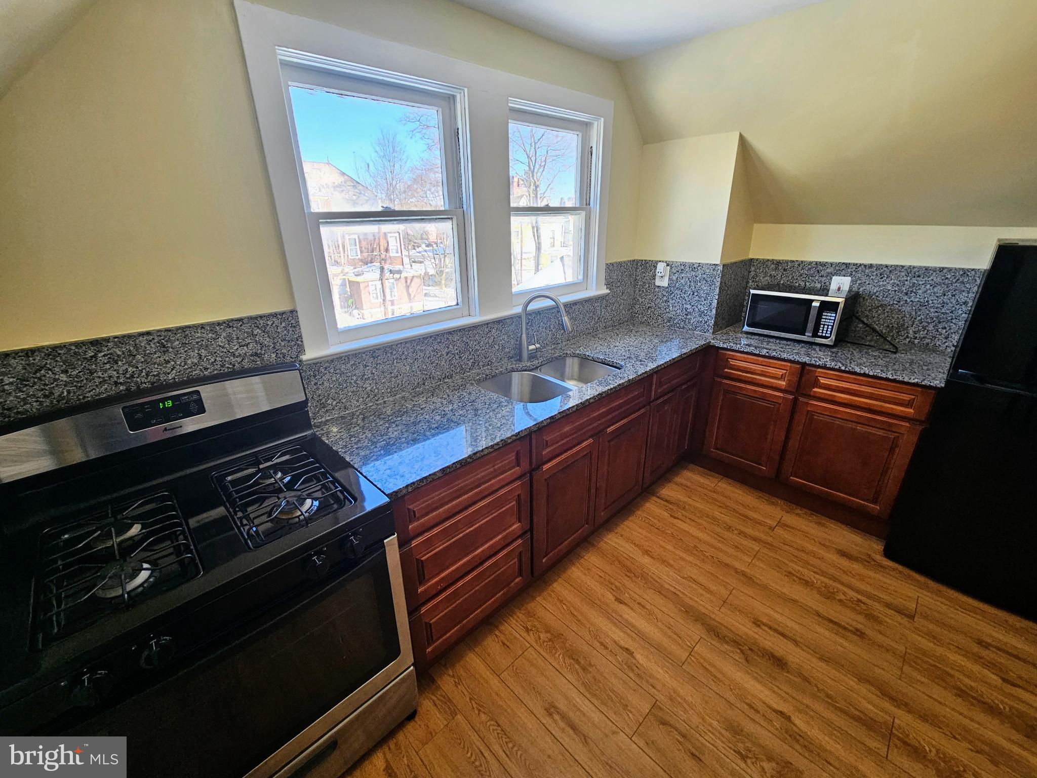 912 Riverside Avenue, Unit 3 Trenton, NJ 08618 - Photo 7 of 17 a kitchen with wooden floors and a stove