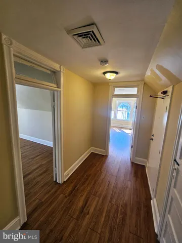 a view of a hallway with wooden floor