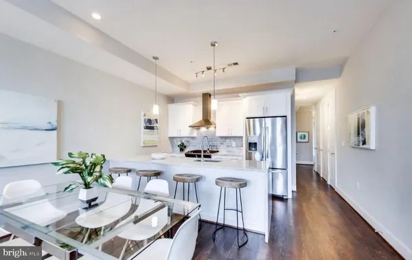 a living room with lots of furniture kitchen view and a flat screen tv
