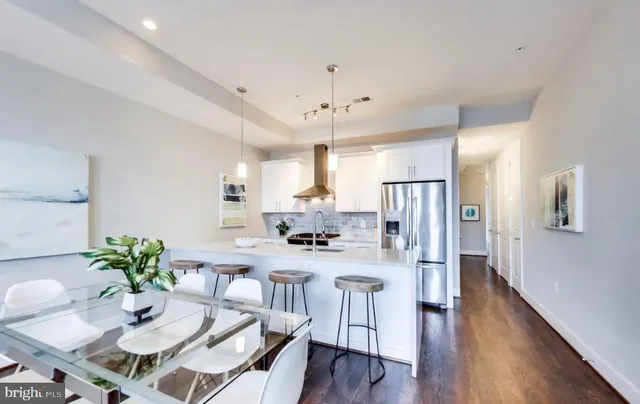 a living room with lots of furniture kitchen view and a flat screen tv