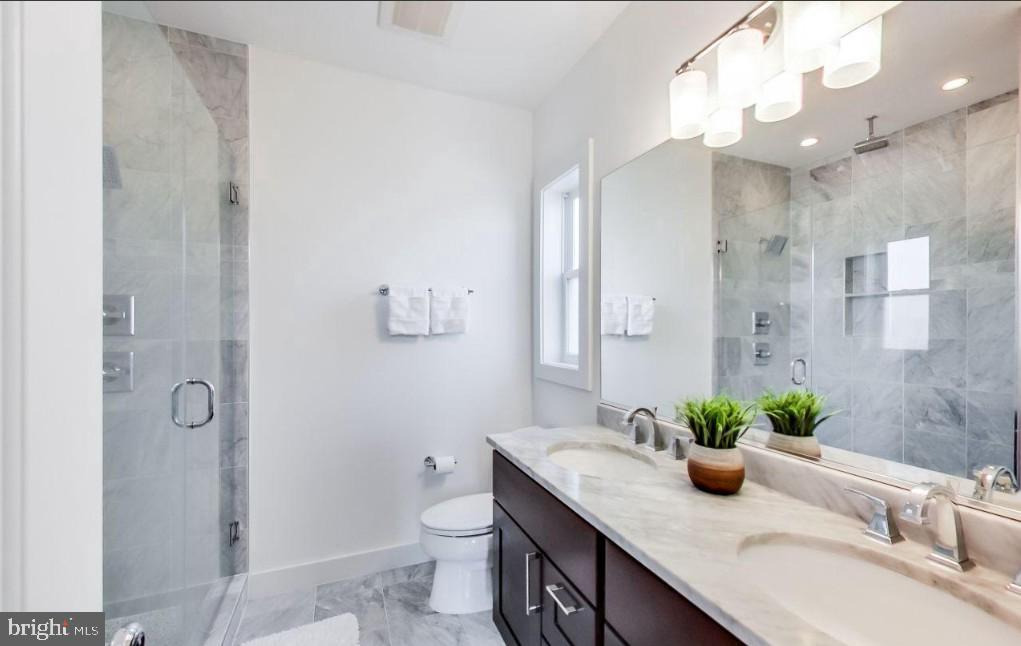 726 Girard Street Northwest, Unit 2 Washington, DC 20001 - Photo 13 of 18 a bathroom with a granite countertop sink a toilet and shower