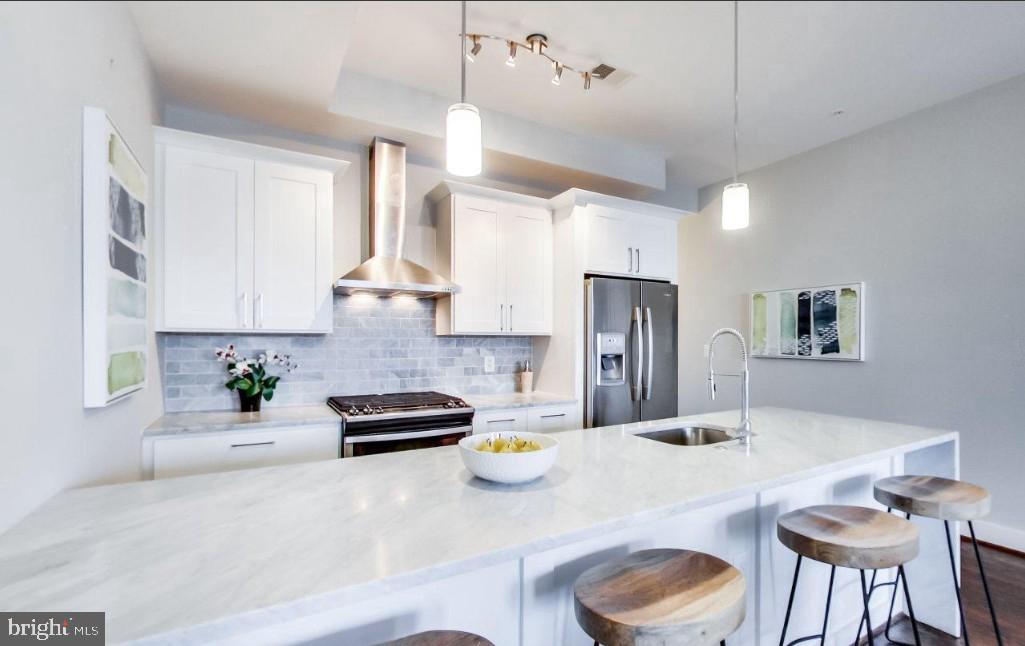 726 Girard Street Northwest, Unit 2 Washington, DC 20001 - Photo 5 of 18 a kitchen with stainless steel appliances granite countertop a refrigerator a sink dishwasher a stove and a dining table with wooden floor