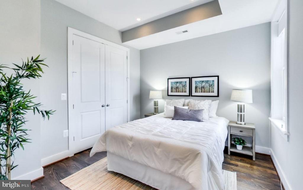 726 Girard Street Northwest, Unit 2 Washington, DC 20001 - Photo 9 of 18 a bedroom with a large bed and a potted plant