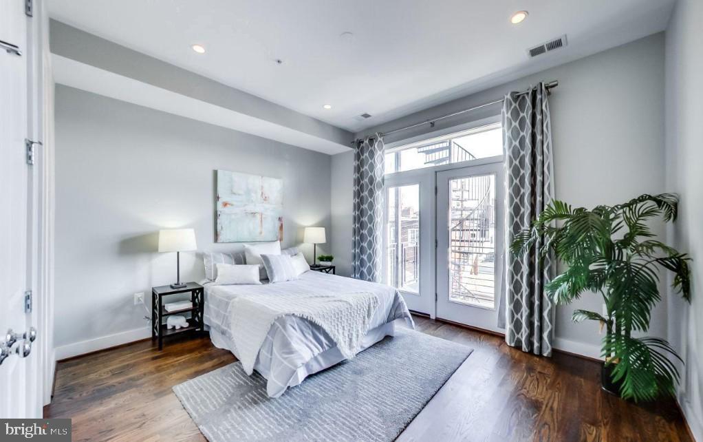 726 Girard Street Northwest, Unit 2 Washington, DC 20001 - Photo 10 of 18 a bedroom with a large bed and a potted plant