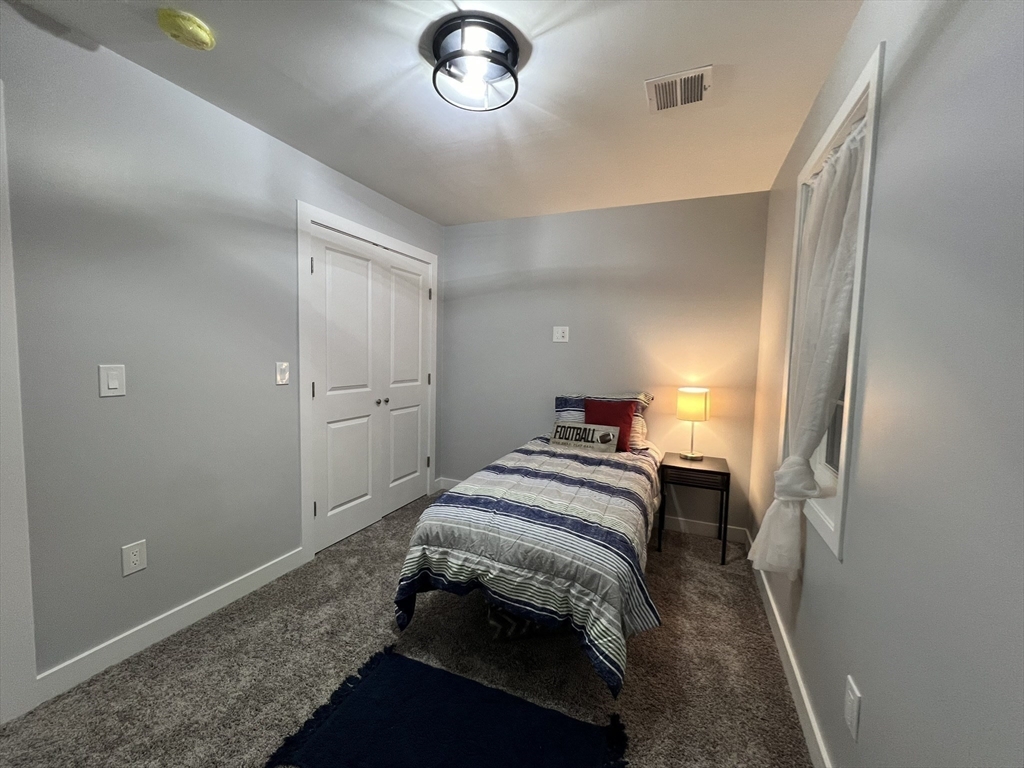 45 Emerald Road Rutland, MA 01543 - Photo 29 of 32 a bedroom with a bed and a chandelier