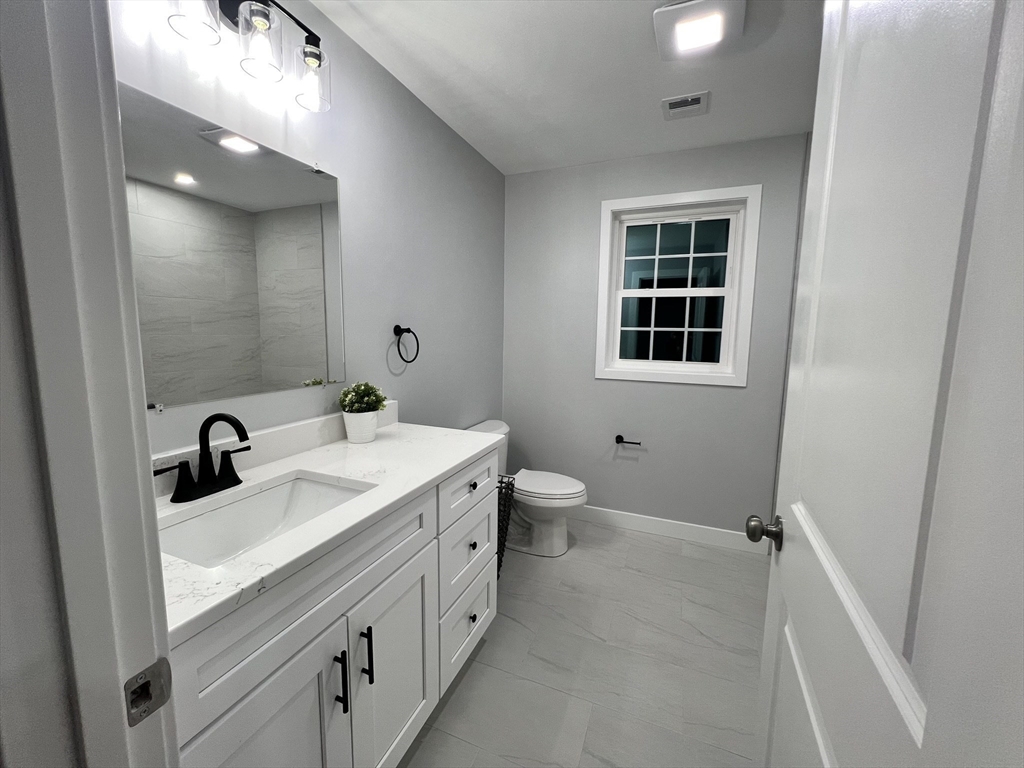 45 Emerald Road Rutland, MA 01543 - Photo 32 of 32 a bathroom with a double vanity sink a toilet and a mirror