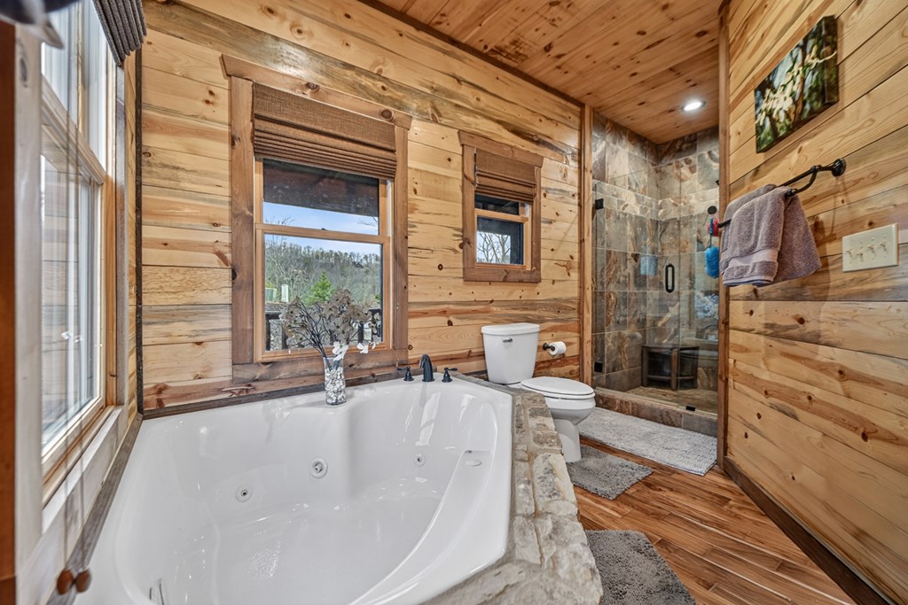467 Deer Crest Road Blue Ridge, GA 30513 - Photo 23 of 79 a spacious bathroom with a tub a sink and large windows
