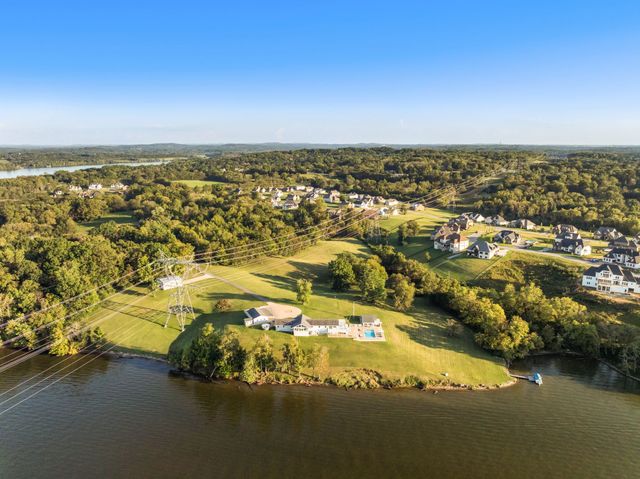 a living room with furniture a ceiling fan and a large window
