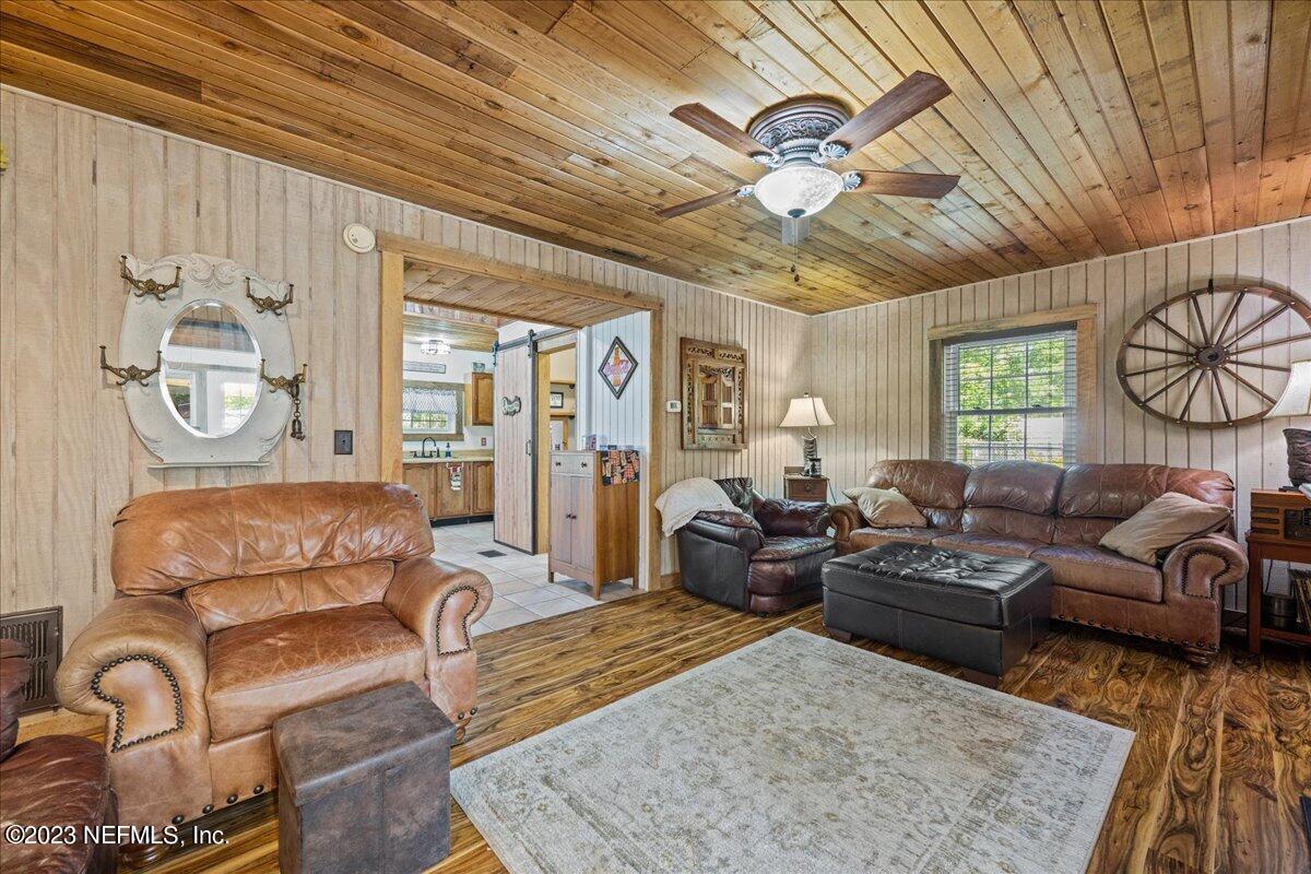 108 Creekside Road Satsuma, FL 32189 - Photo 16 of 40 a living room with furniture a rug and a chandelier