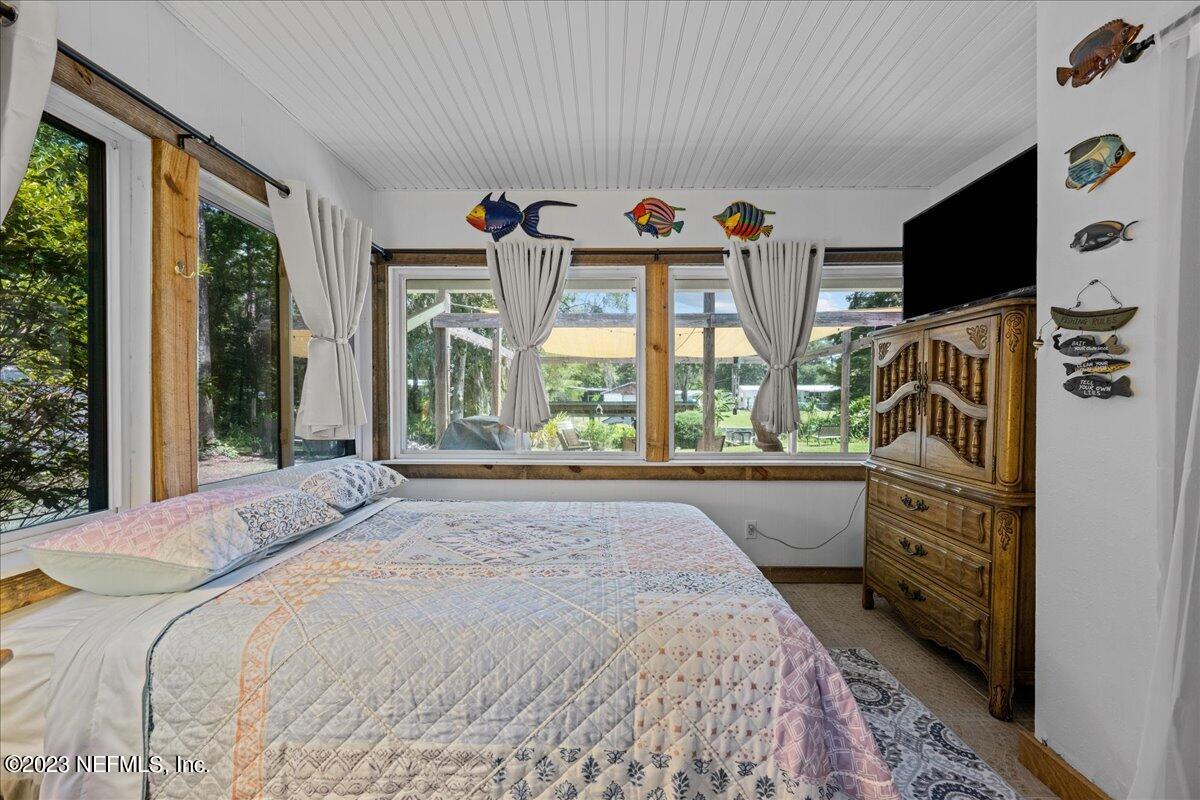 108 Creekside Road Satsuma, FL 32189 - Photo 19 of 40 a spacious bedroom with a large bed and a flat tv screen on dresser