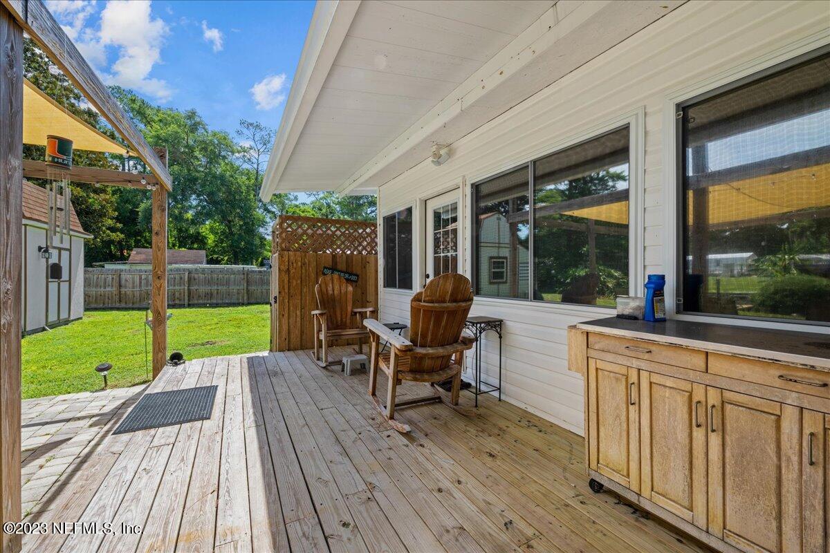 108 Creekside Road Satsuma, FL 32189 - Photo 26 of 40 a view of a deck with table and chairs potted plants with wooden floor and fence