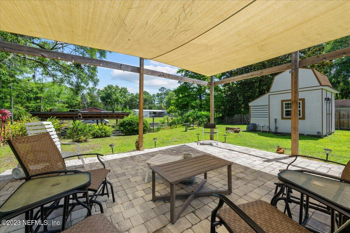 108 Creekside Road Satsuma, FL 32189 - Photo 27 of 40 a view of a patio with a table chairs and a backyard