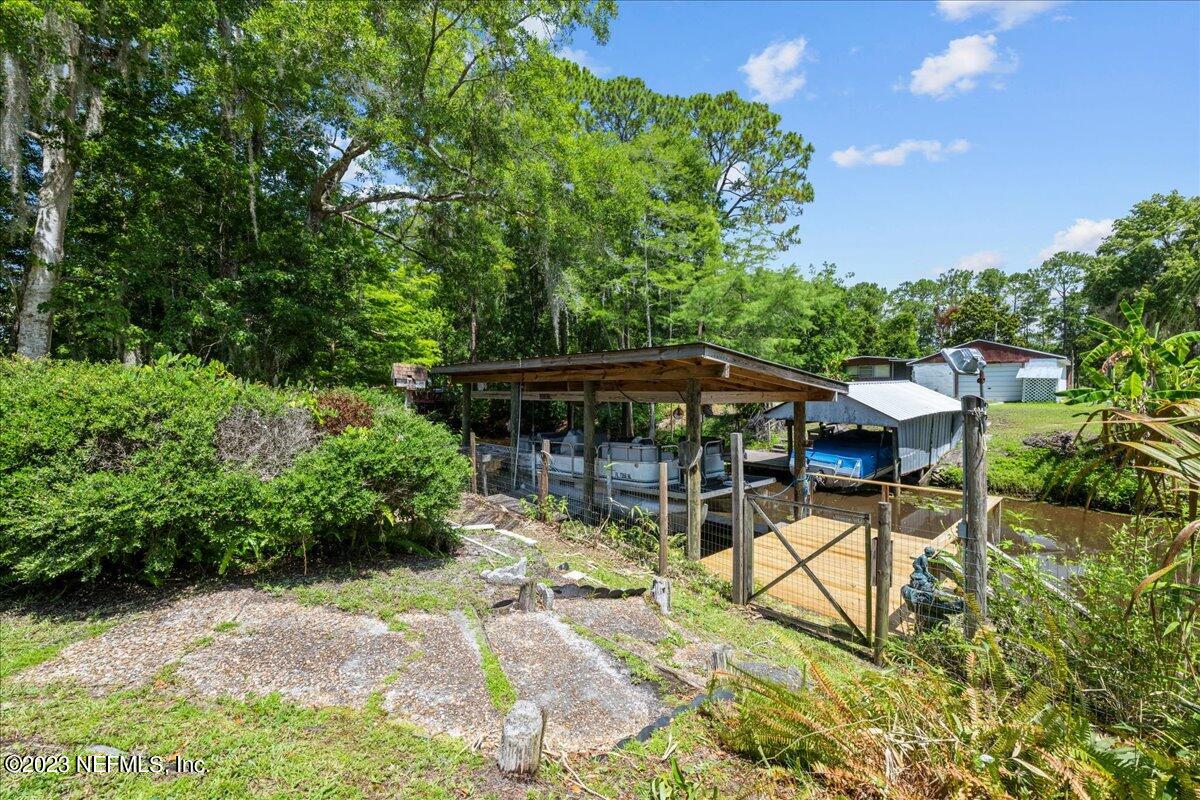 108 Creekside Road Satsuma, FL 32189 - Photo 32 of 40 a view of a patio with table and chairs under an umbrella