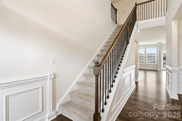 a view of a hallway with wooden floor and staircase