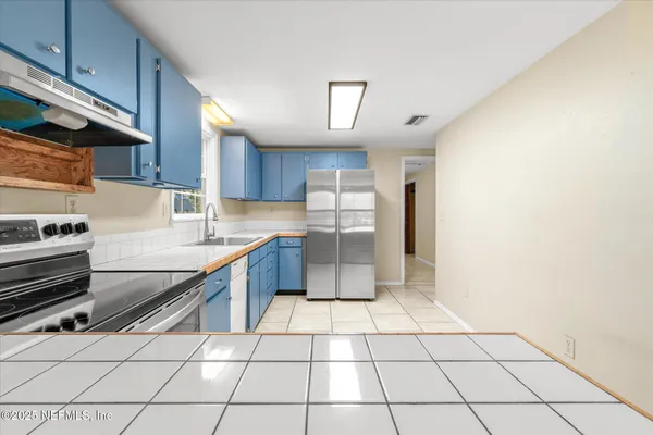 a kitchen with stainless steel appliances a sink a stove a microwave and cabinets