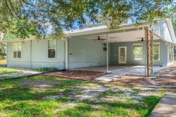 a view of a house with a yard and tree s